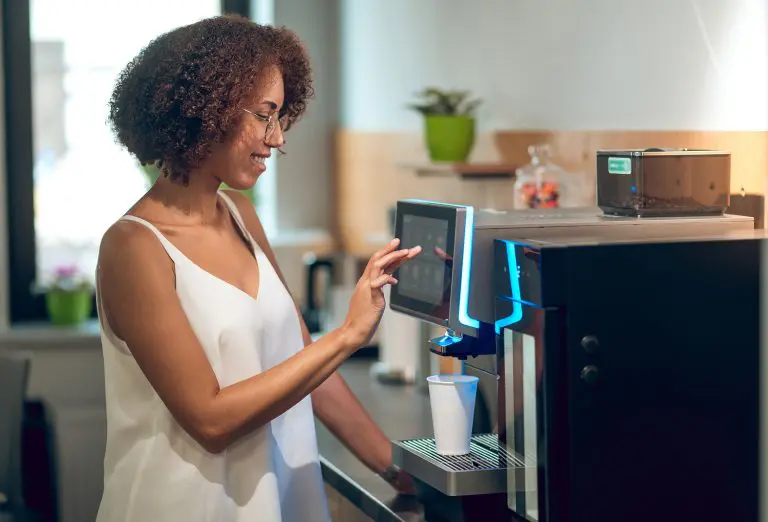 Image of a woman operating a coffee machine